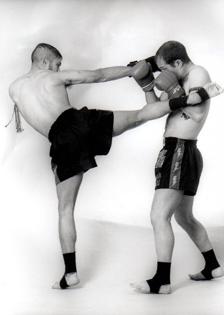 Two opponents doing Thai boxing kick and blocks